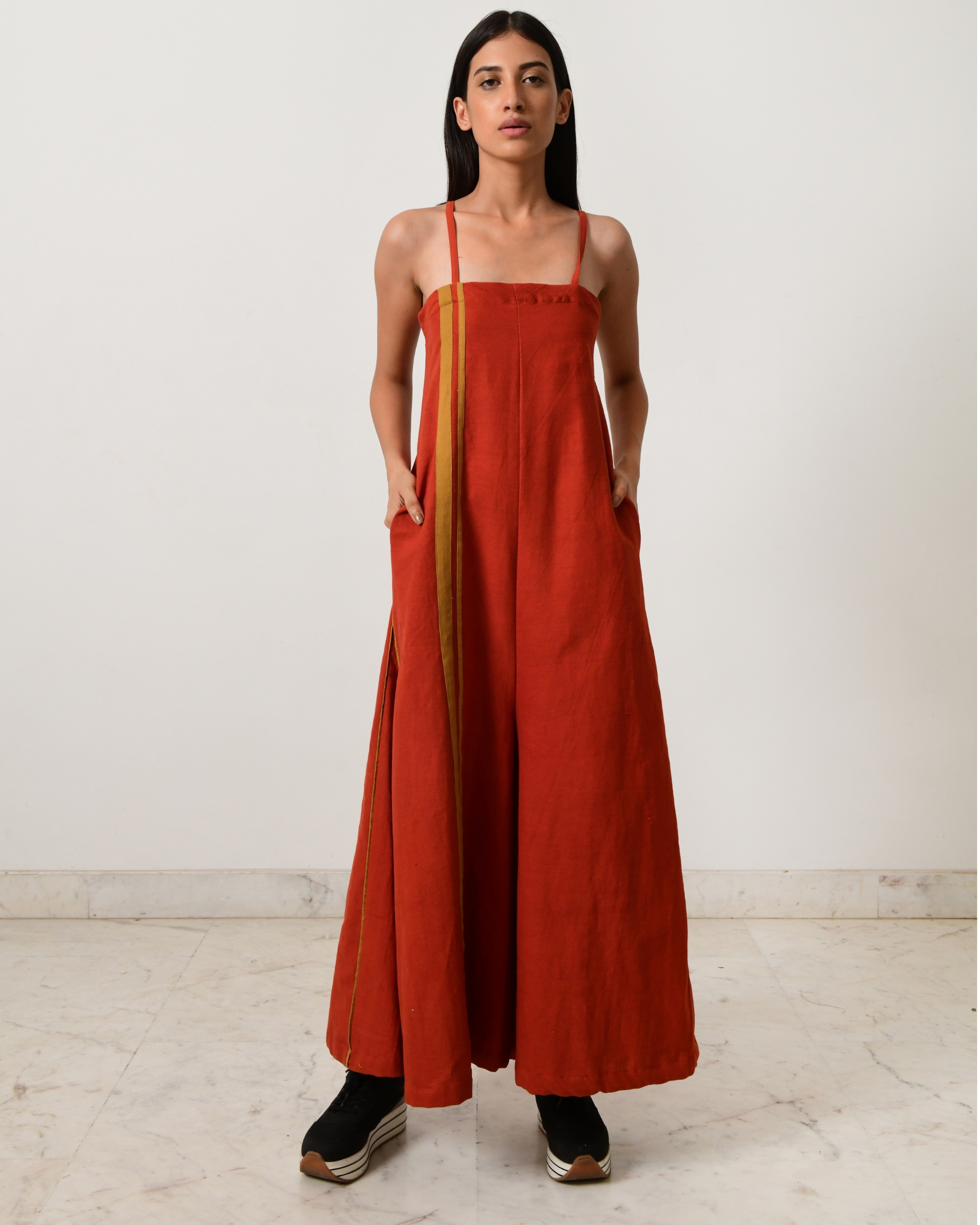 Rust strappy jumpsuit with fire strap piping