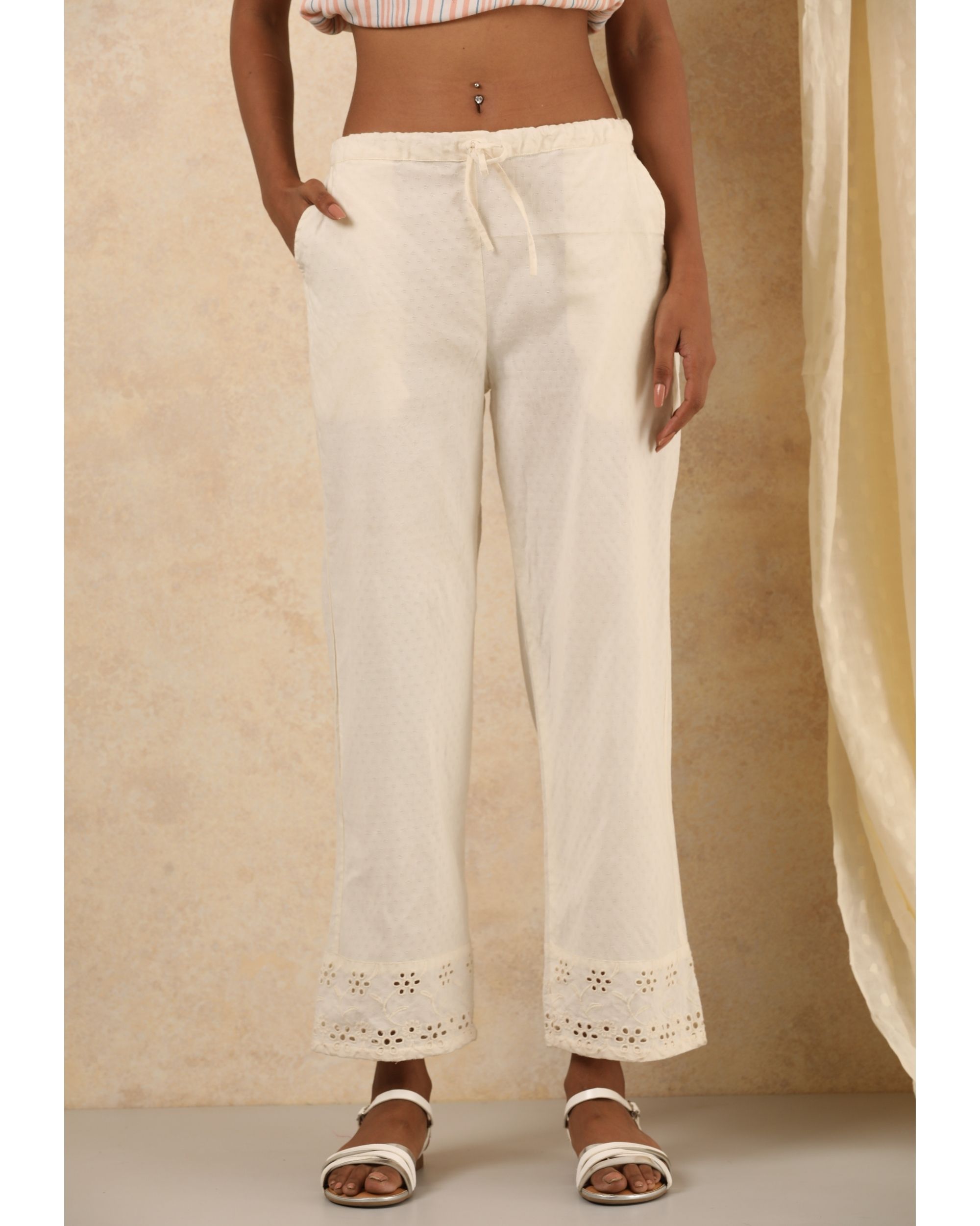White cotton pants with embroidered detailing at hem